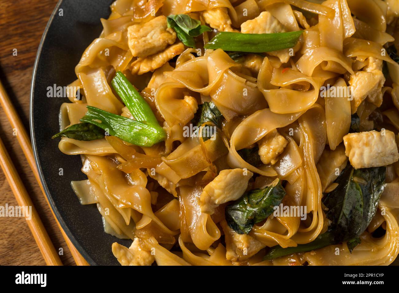 Spicy Homemade Thai Drunken Noodles with Chicken and Basil Stock Photo