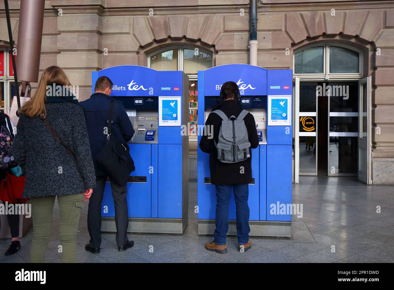 People buying SCNF TER regional train tickets from a ticket machine at Gare de Strasbourg-Ville, Grand Est, France. Stock Photo