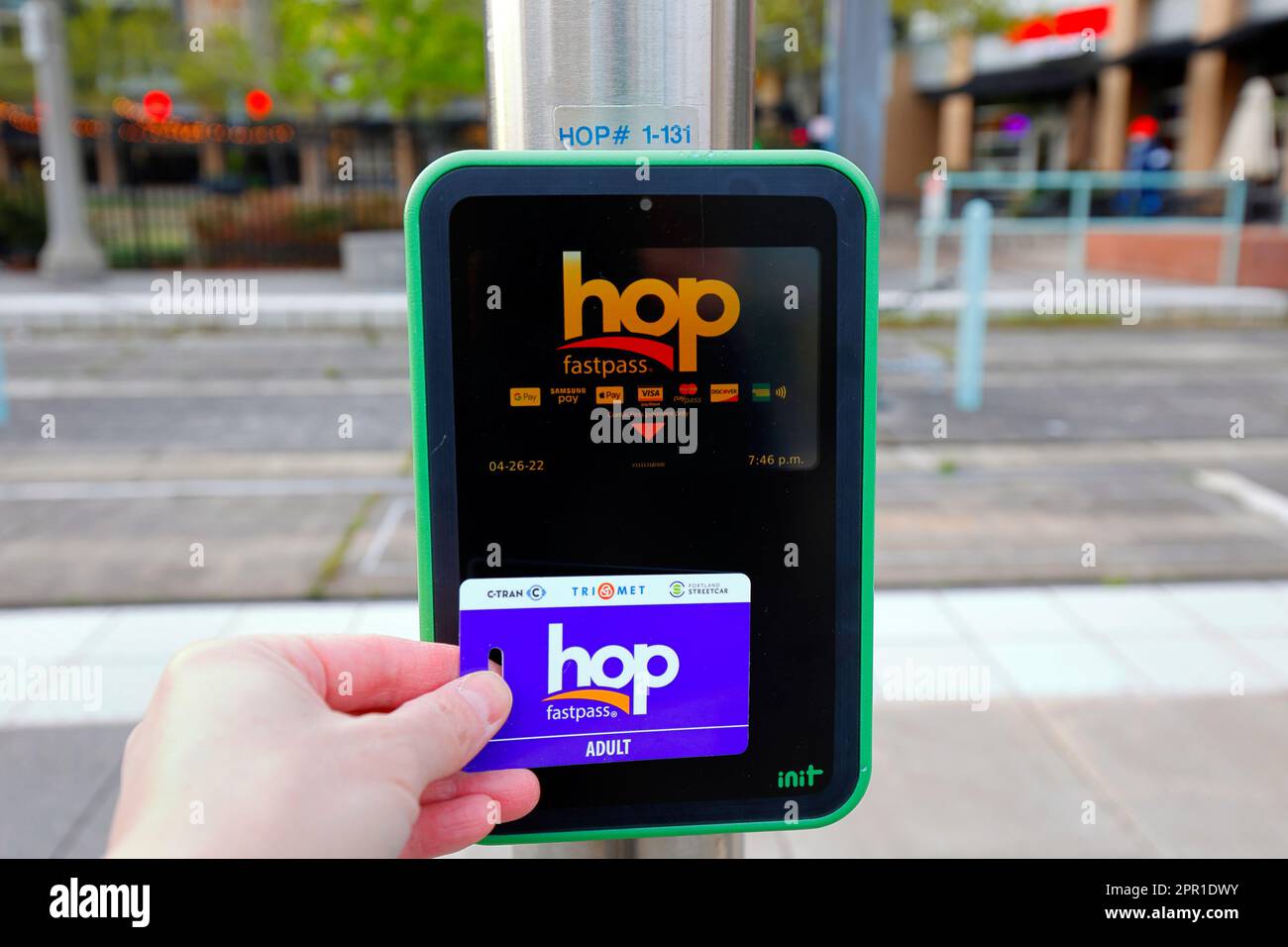 A person taps a HOP Fastpass transit card to a contactless payment device at a Trimet lightrail station in Beaverton, Oregon near Portland. Stock Photo