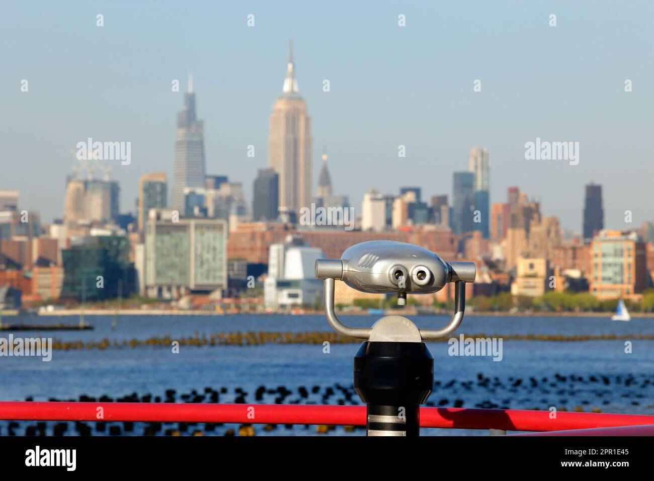 Hi Spy viewing binoculars aimed toward the New York City skyline with the Empire State Building in Midtown Manhattan at its center. Stock Photo