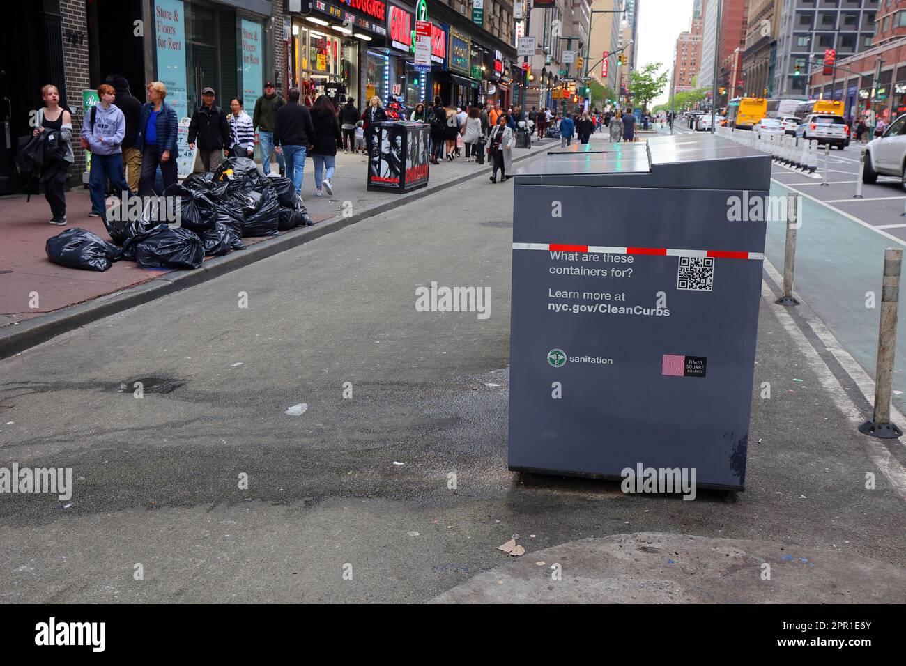 Rat proof trash collection bins on a filthy street in Times Square. The storage containers are approved under NYC's Clean Curbs program for the tempor Stock Photo