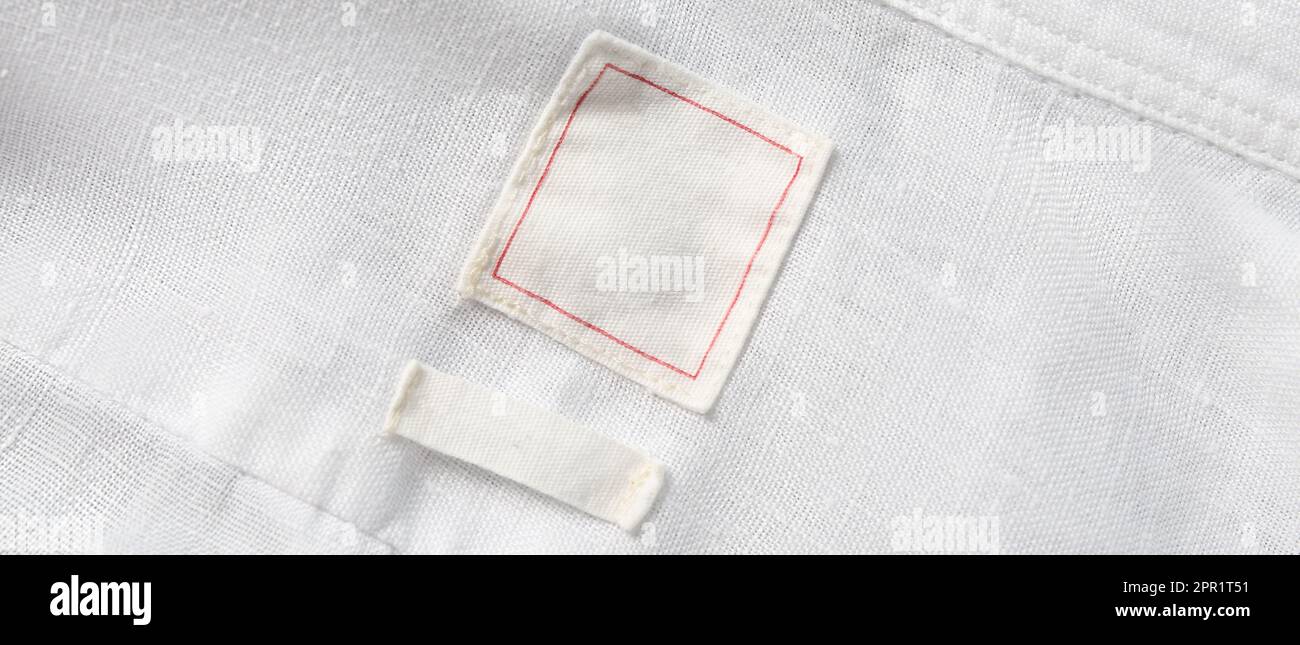 Blank clothing labels on white shirt, top view. Banner design Stock