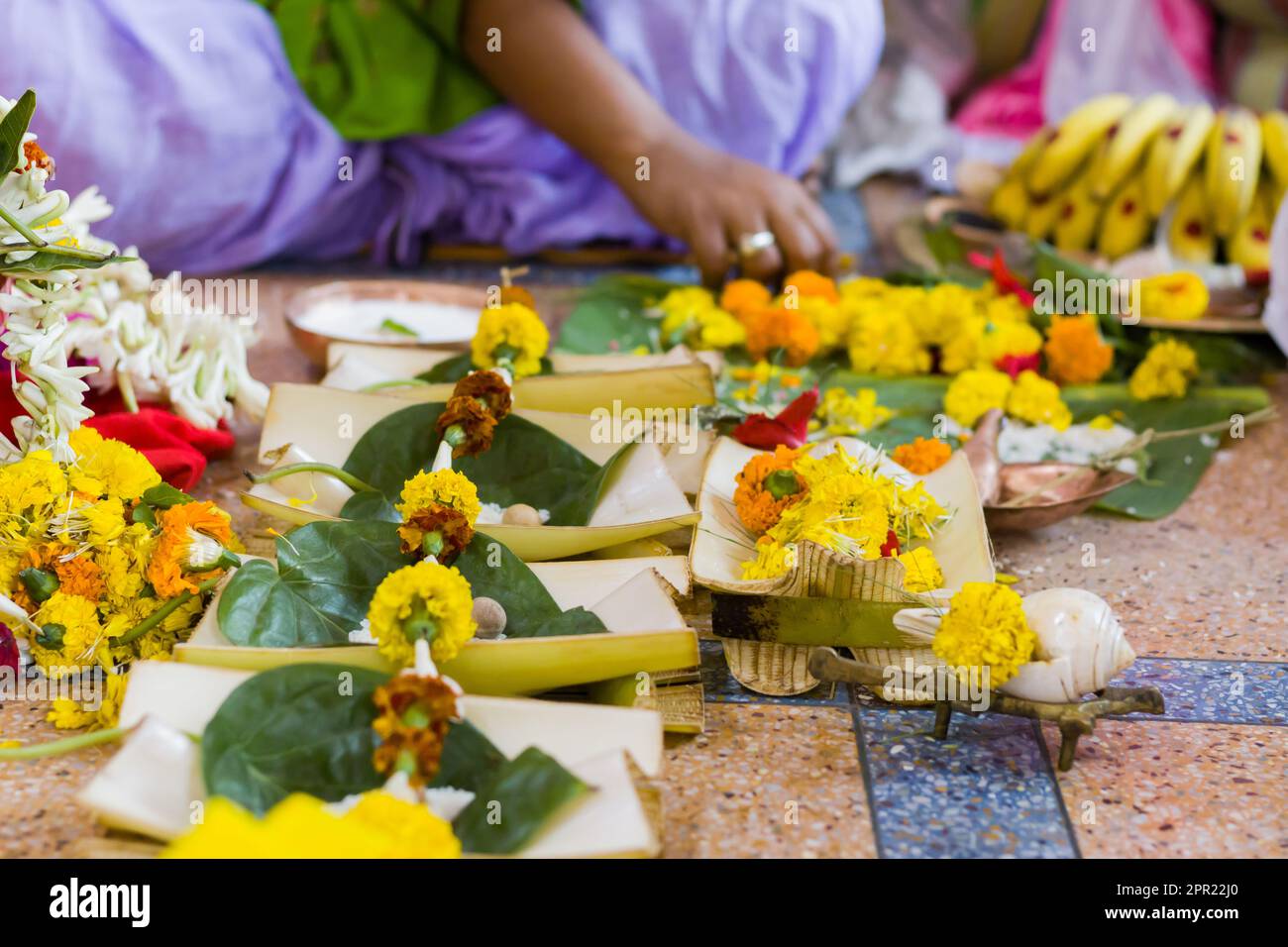 Hindu puja rituals being performed with flowers in front of priest during pooja, wedding