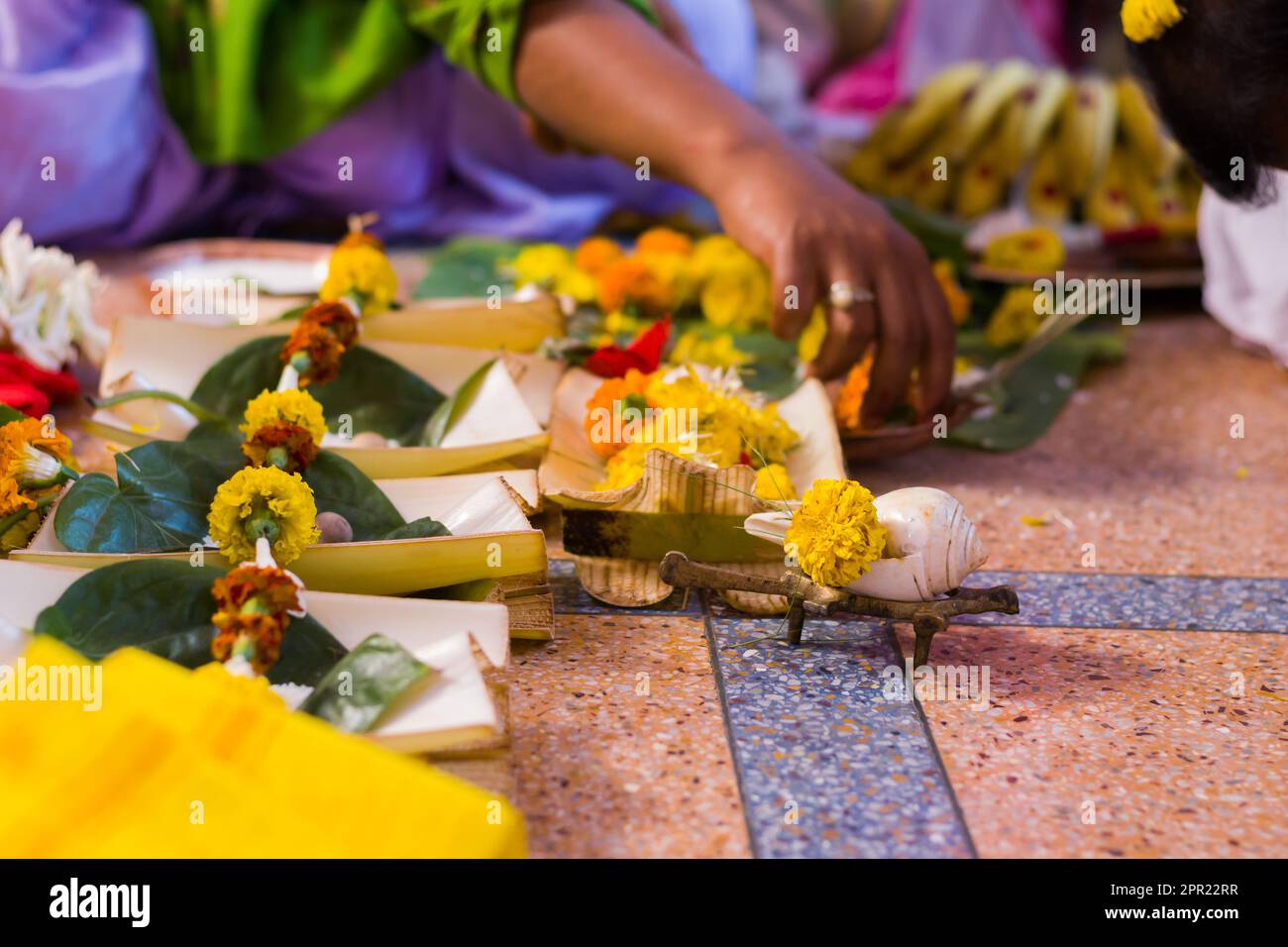 Hindu puja rituals being performed with flowers in front of priest