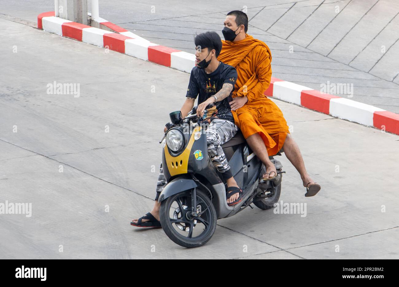 SAMUT PRAKAN, THAILAND, JAN 31 2023, A man rides a motorcycle with a Buddhist monk Stock Photo