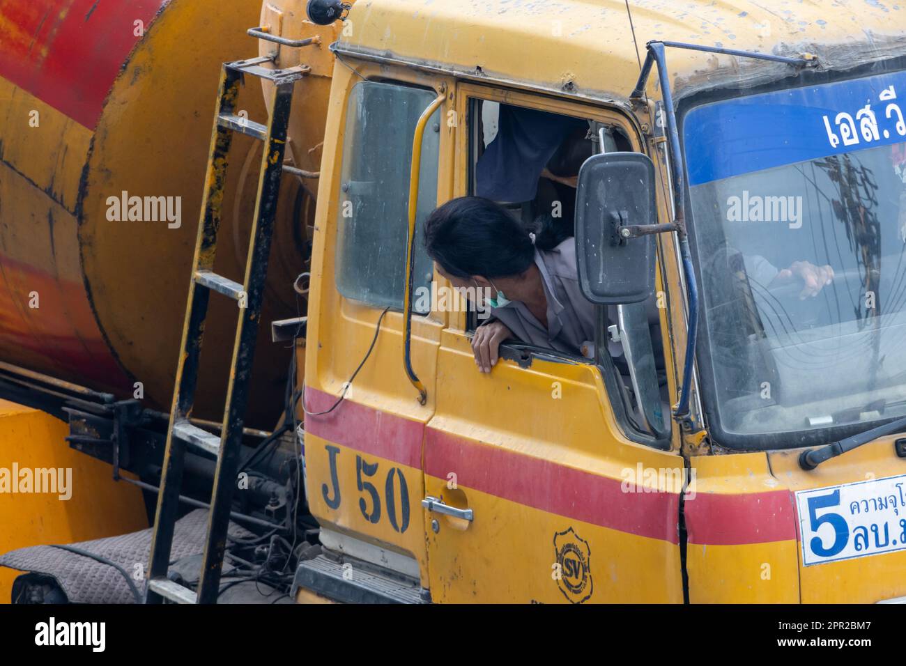 SAMUT PRAKAN, THAILAND, JAN 31 2023, The blender truck driver looks out of the open window and backs up Stock Photo