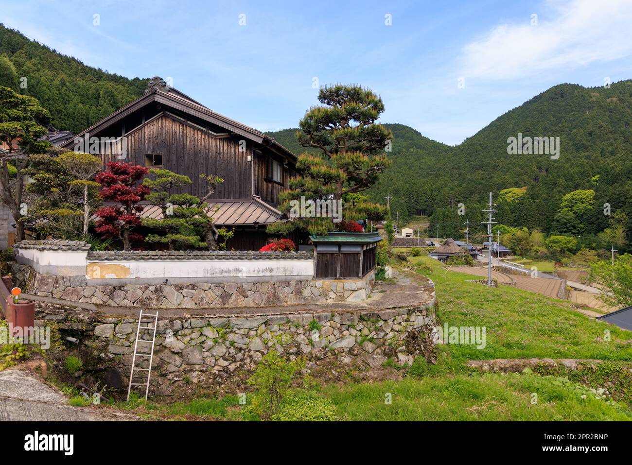 Ladder on stone wall by traditional Japanese house in small mountain