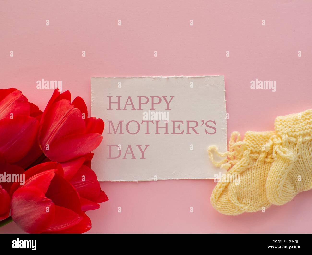https://c8.alamy.com/comp/2PR2JJT/red-tulips-flowers-and-yellow-booties-for-a-newborn-on-pink-background-with-happy-mothers-day-mothers-day-greeting-card-writing-wishes-for-mother-k-2PR2JJT.jpg