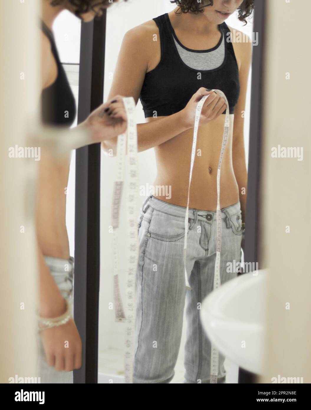 Anorexia, measuring tape and body of woman in mirror for weight loss, eating disorder and body image. Depression, mental health and sad with female at Stock Photo