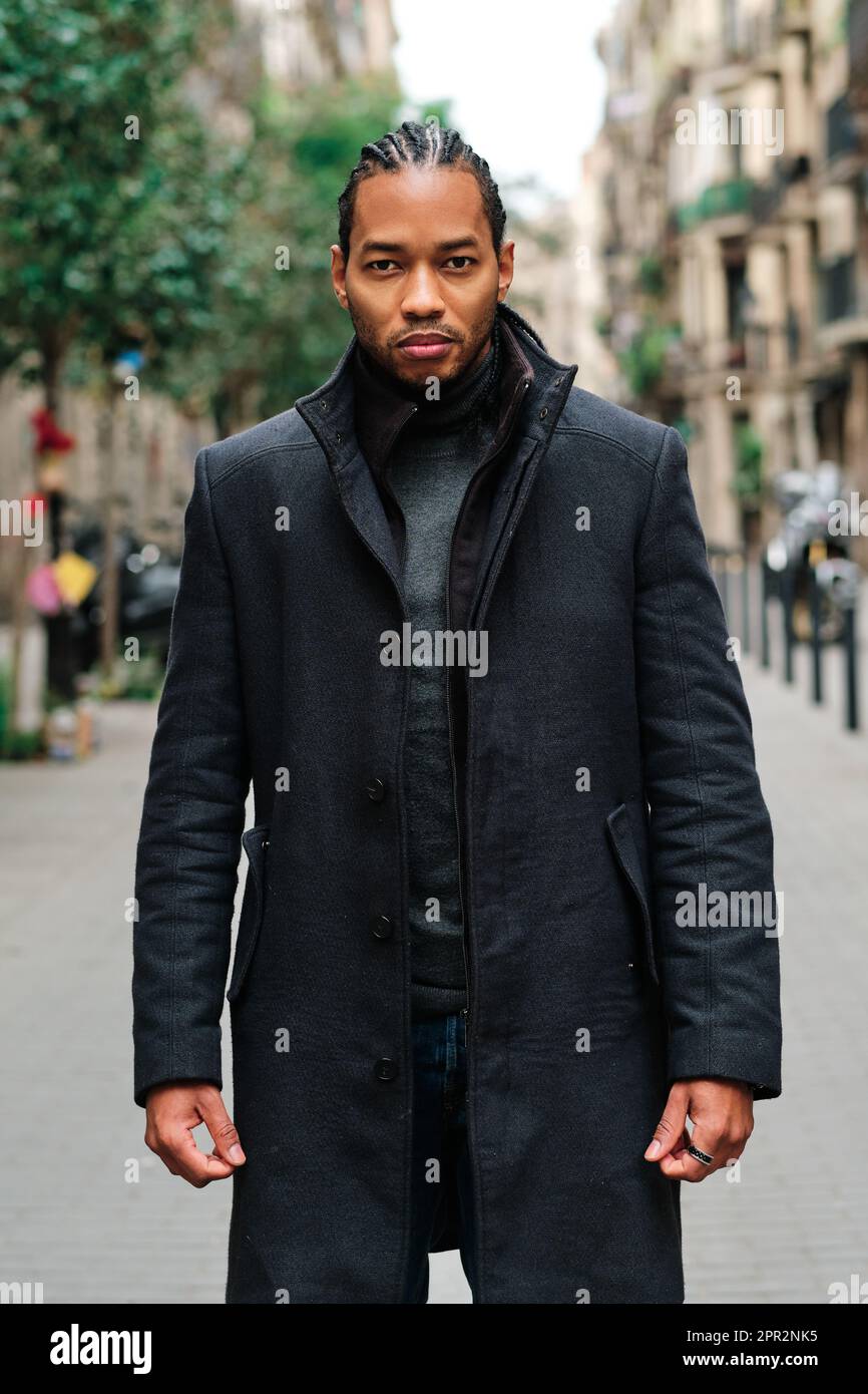 Stylish African American man looking at camera with serious face while posing outdoors on the street. Stock Photo