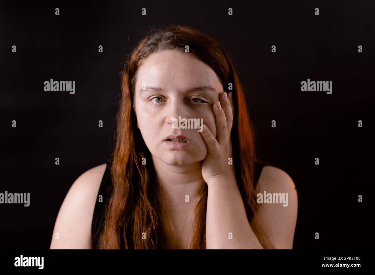 Tired young woman running hand down face. Weakness and suffering