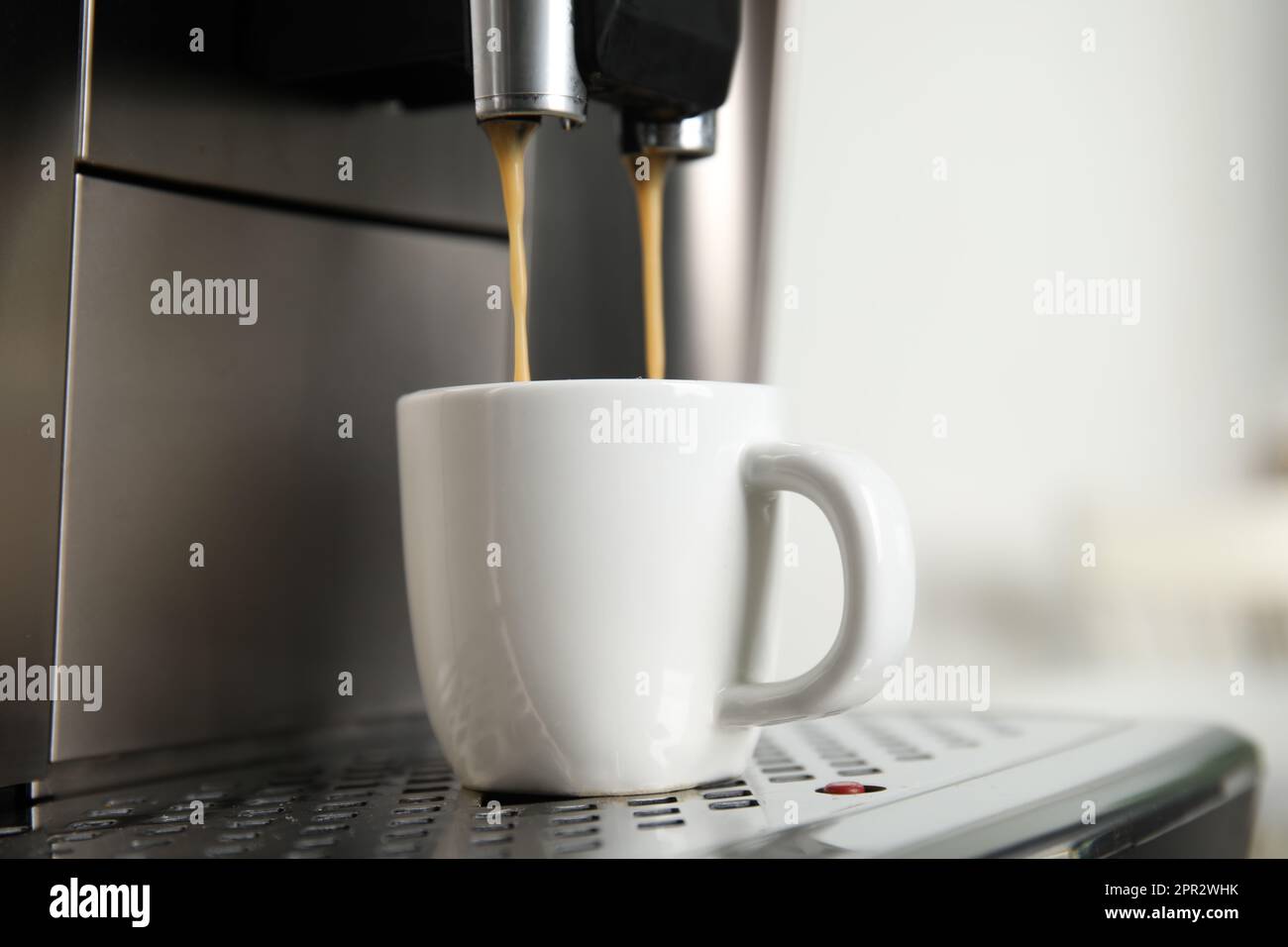 Espresso machine pouring coffee into cup against light background, closeup  Stock Photo - Alamy