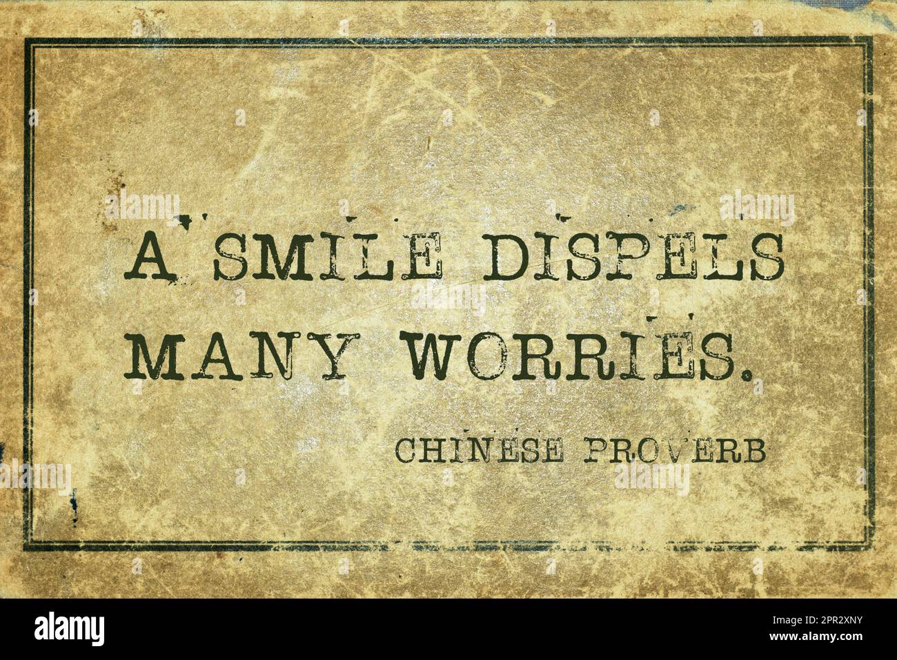 A smile dispels many worries - ancient Chinese proverb printed on grunge vintage cardboard Stock Photo