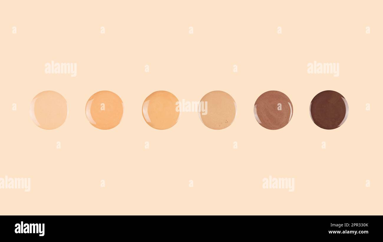 Diverse skin tone makeup foundation drops on beige background Stock
