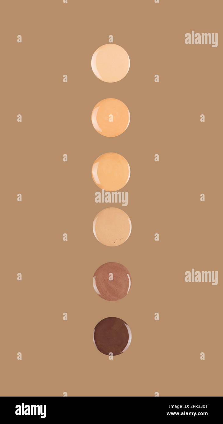 Diverse skin tone makeup foundation drops on brown background Stock