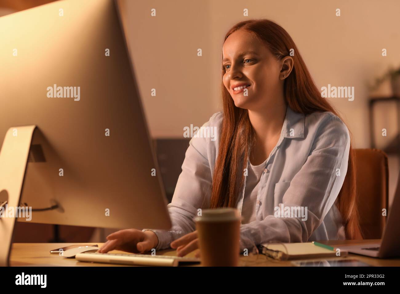 Female programmer working with computer in office at night Stock Photo ...
