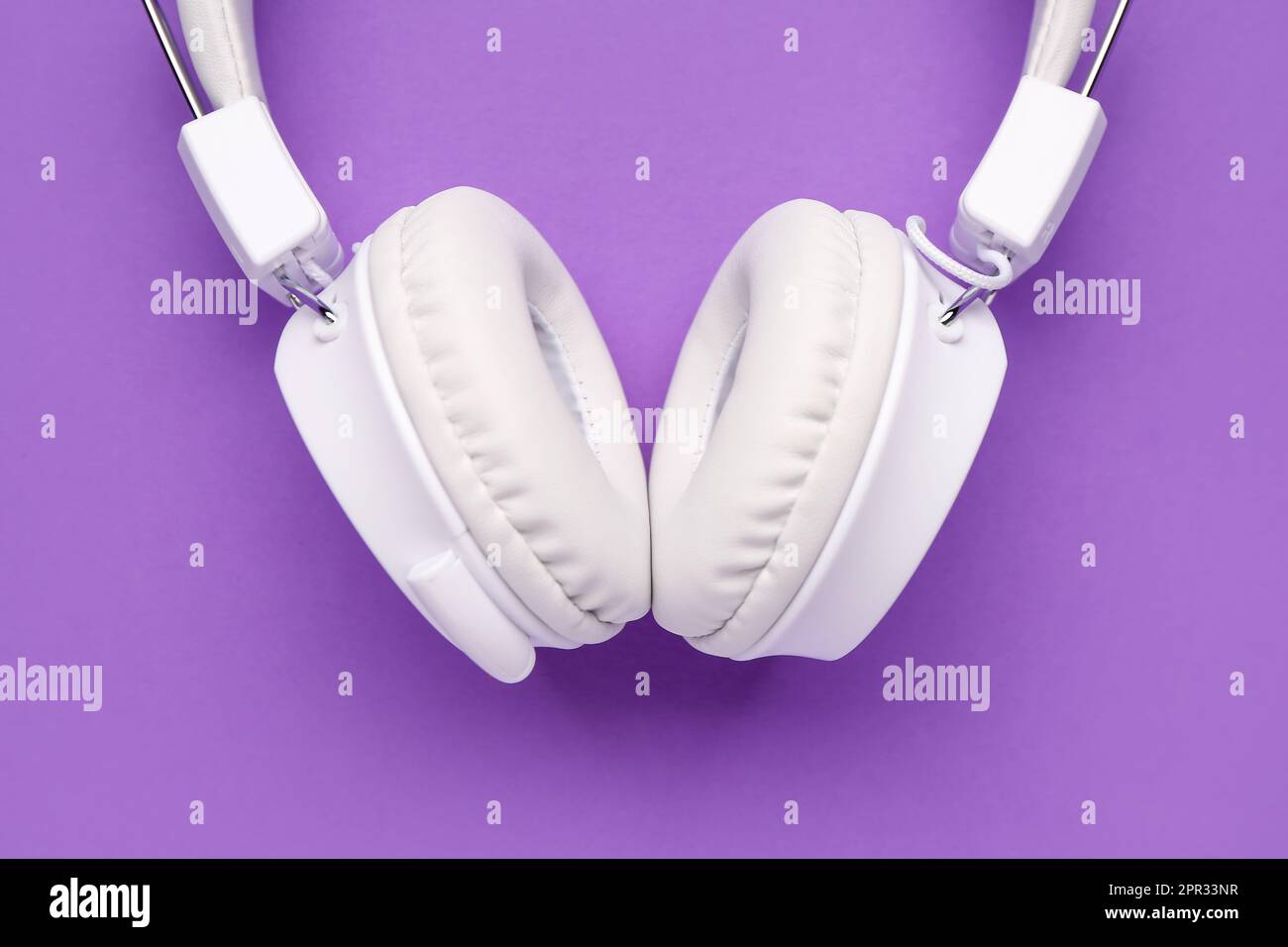 Modern white headphones on purple background Stock Photo Alamy