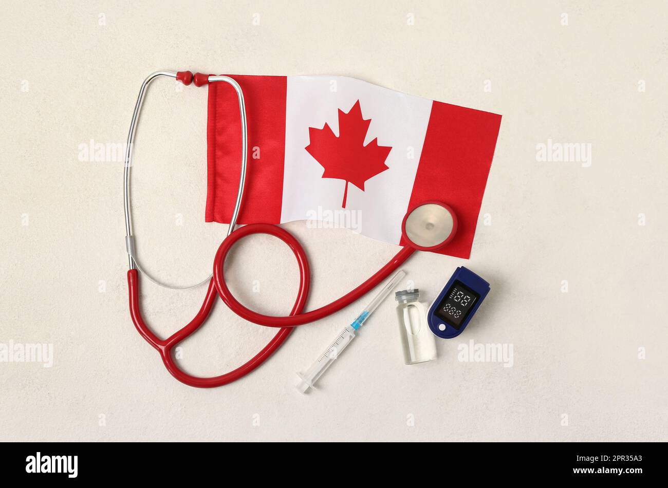 Flag of Canada with stethoscope, syringe, ampule and on