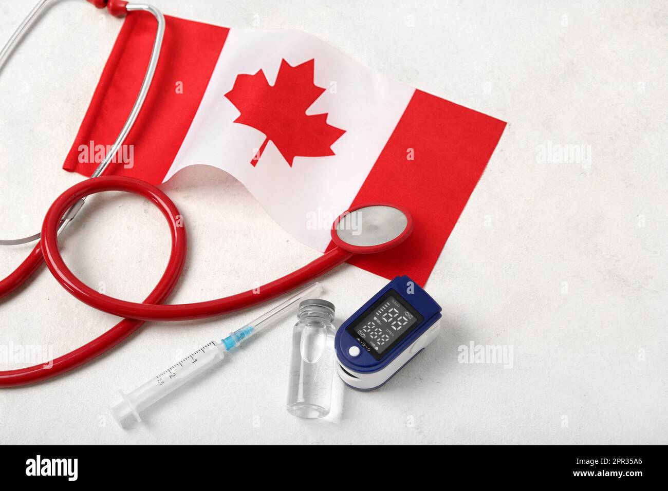 Flag of Canada with stethoscope, syringe, ampule and on