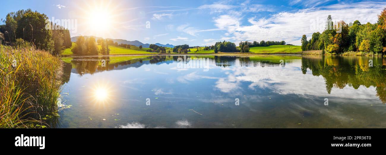panoramic landscape with lake at springtime in front of mountain range Stock Photo