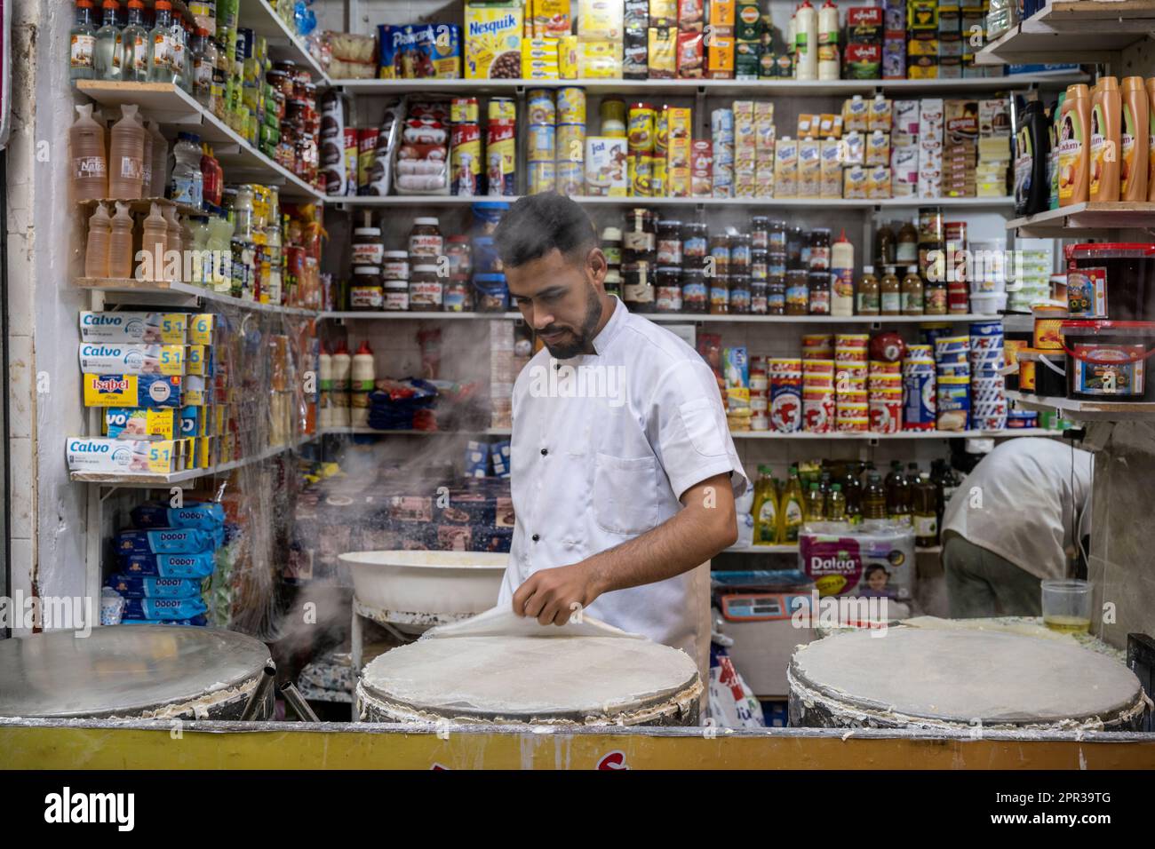 Man preparing pasta sheets to make typical Moroccan sweets in a street stall in the medina of Tangier. Stock Photo
