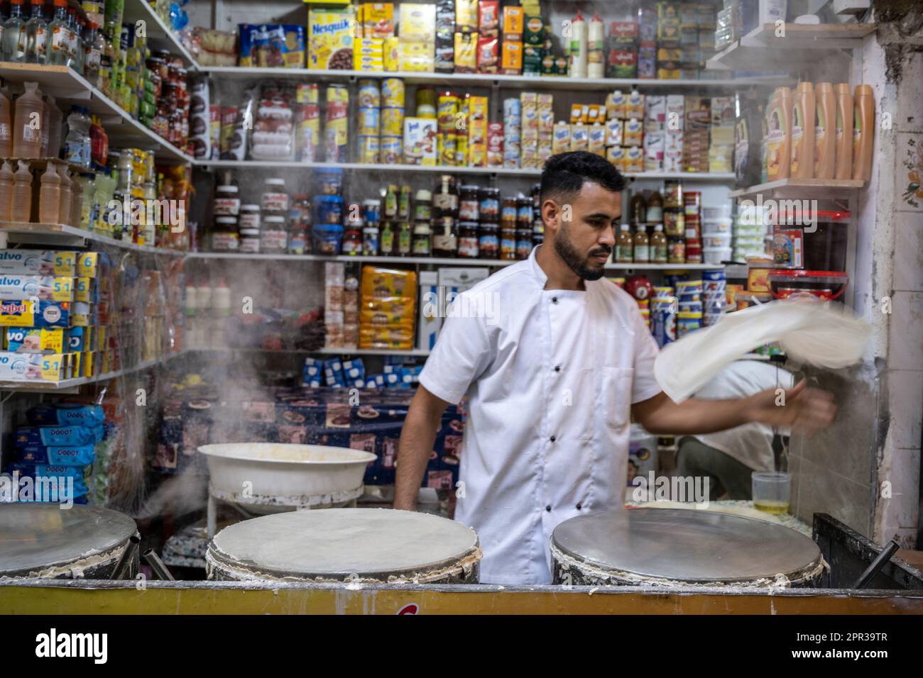 Man preparing pasta sheets to make typical Moroccan sweets in a street stall in the medina of Tangier. Stock Photo