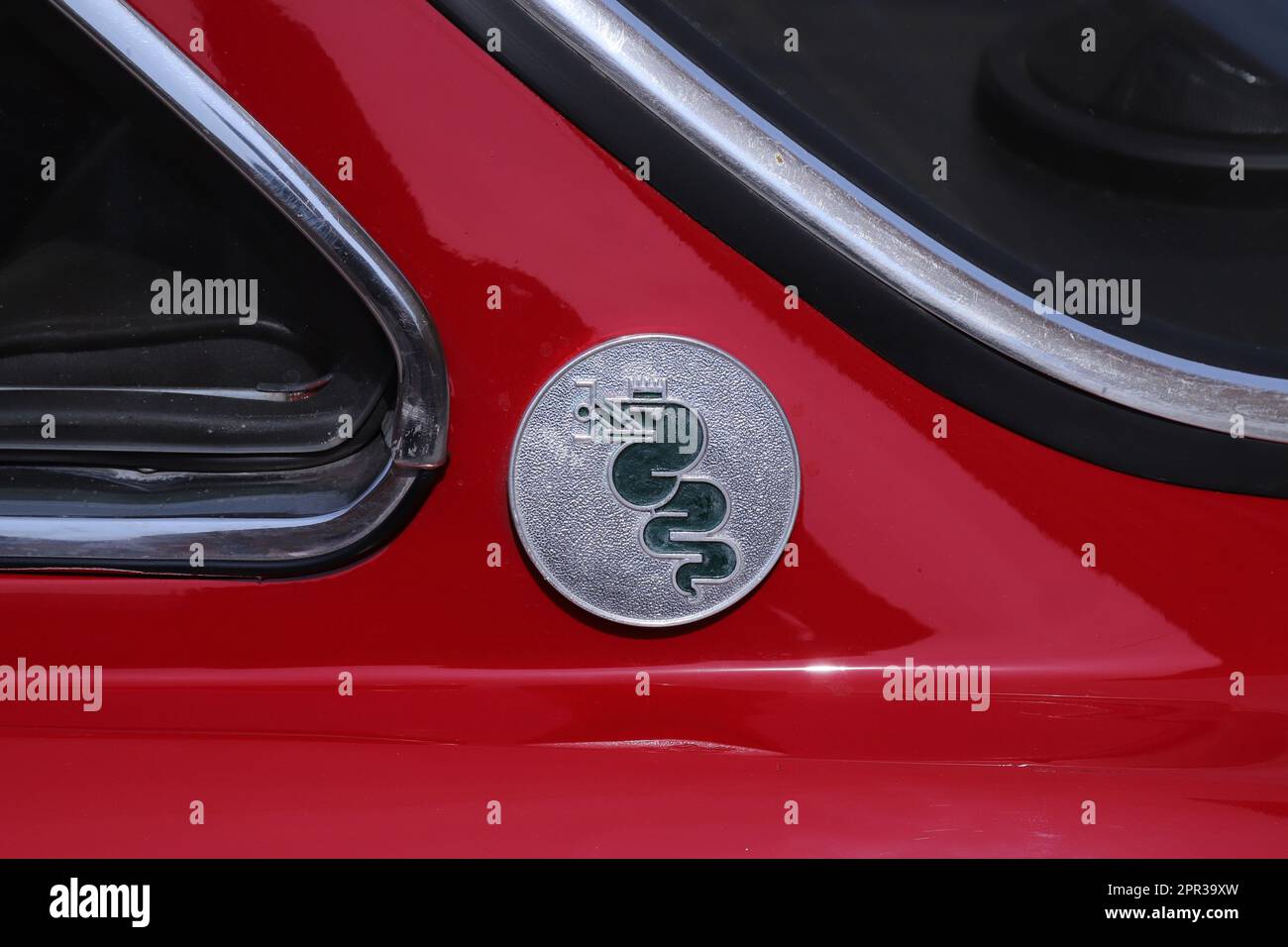 Italy, april 2023, metallic logo of the Alfa Romeo with snake, Spider Duetto vintage car, public automotive exhibition of classic cars Stock Photo