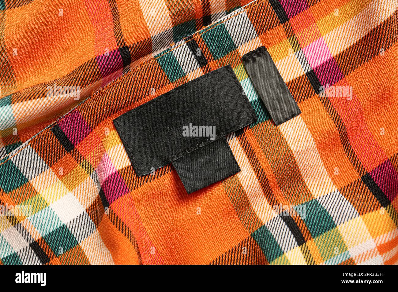 Blank clothing label on checkered apparel, closeup Stock Photo Alamy