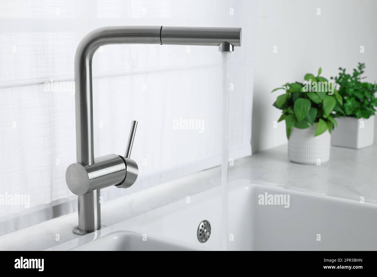 Stream of water flowing from tap in kitchen Stock Photo