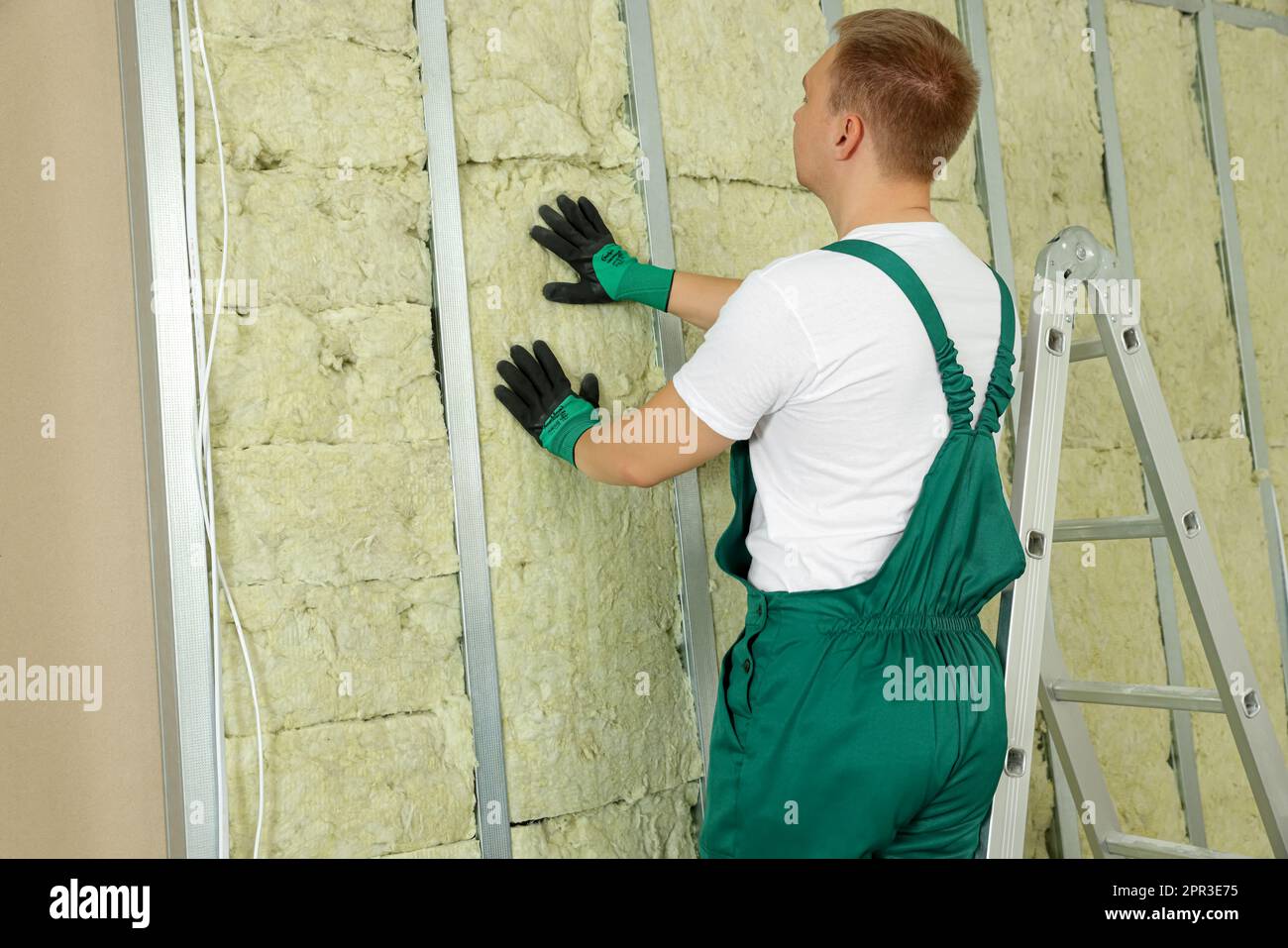 Worker installing thermal insulation material on wall indoors Stock ...