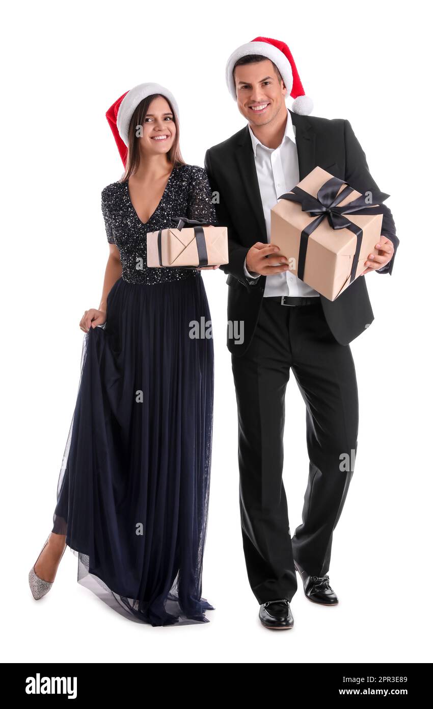 Beautiful happy couple in Santa hats holding Christmas gifts on white ...