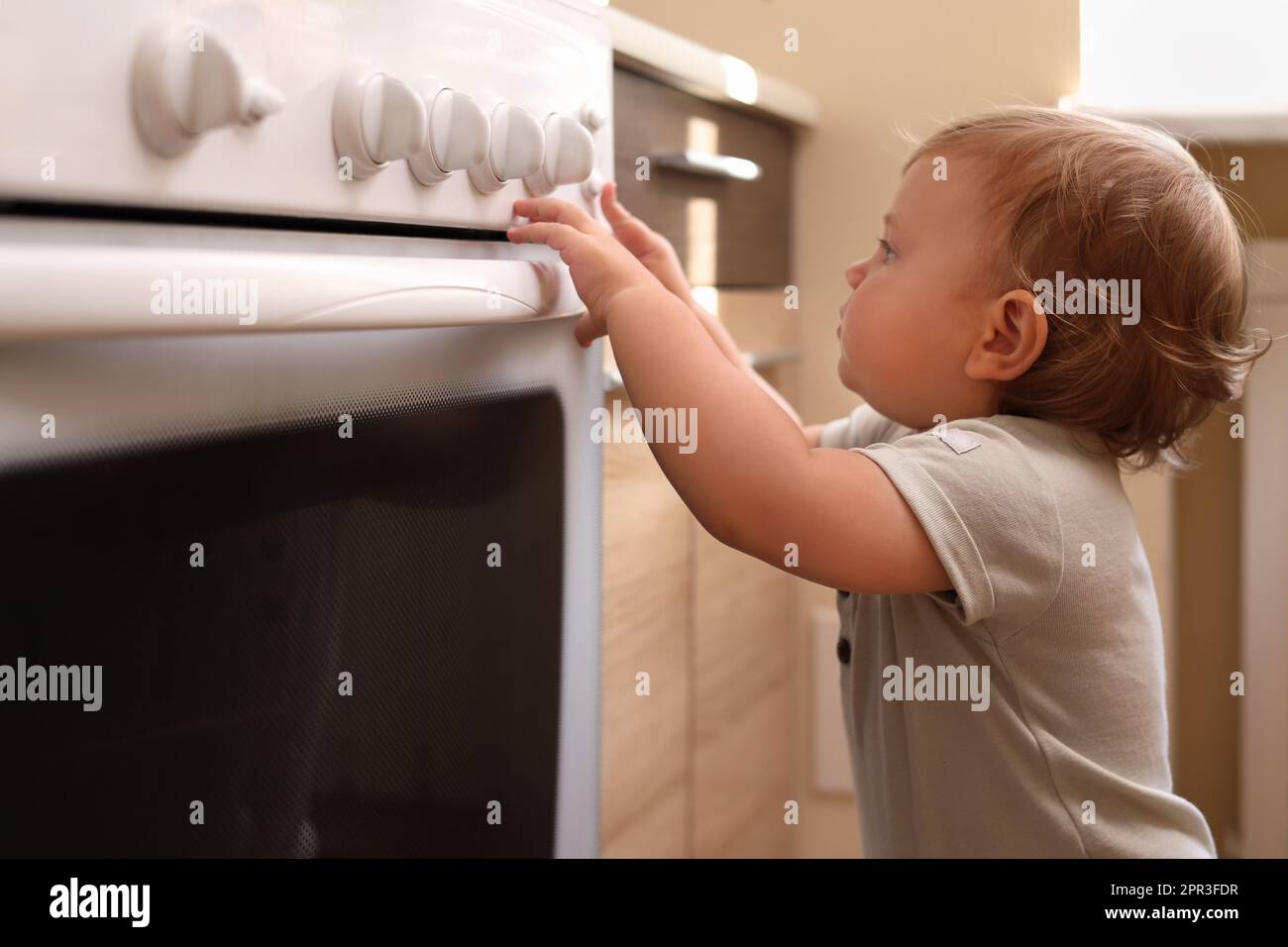 https://c8.alamy.com/comp/2PR3FDR/little-child-playing-with-gas-stove-indoors-dangers-in-kitchen-2PR3FDR.jpg