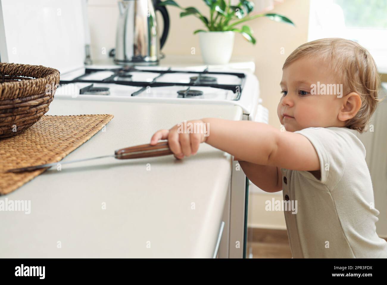 Child touches hot stove in the home. Dangerous situation in the kitchen.  Red-hot surface of hob Stock Photo by ©rbkomar 416451342