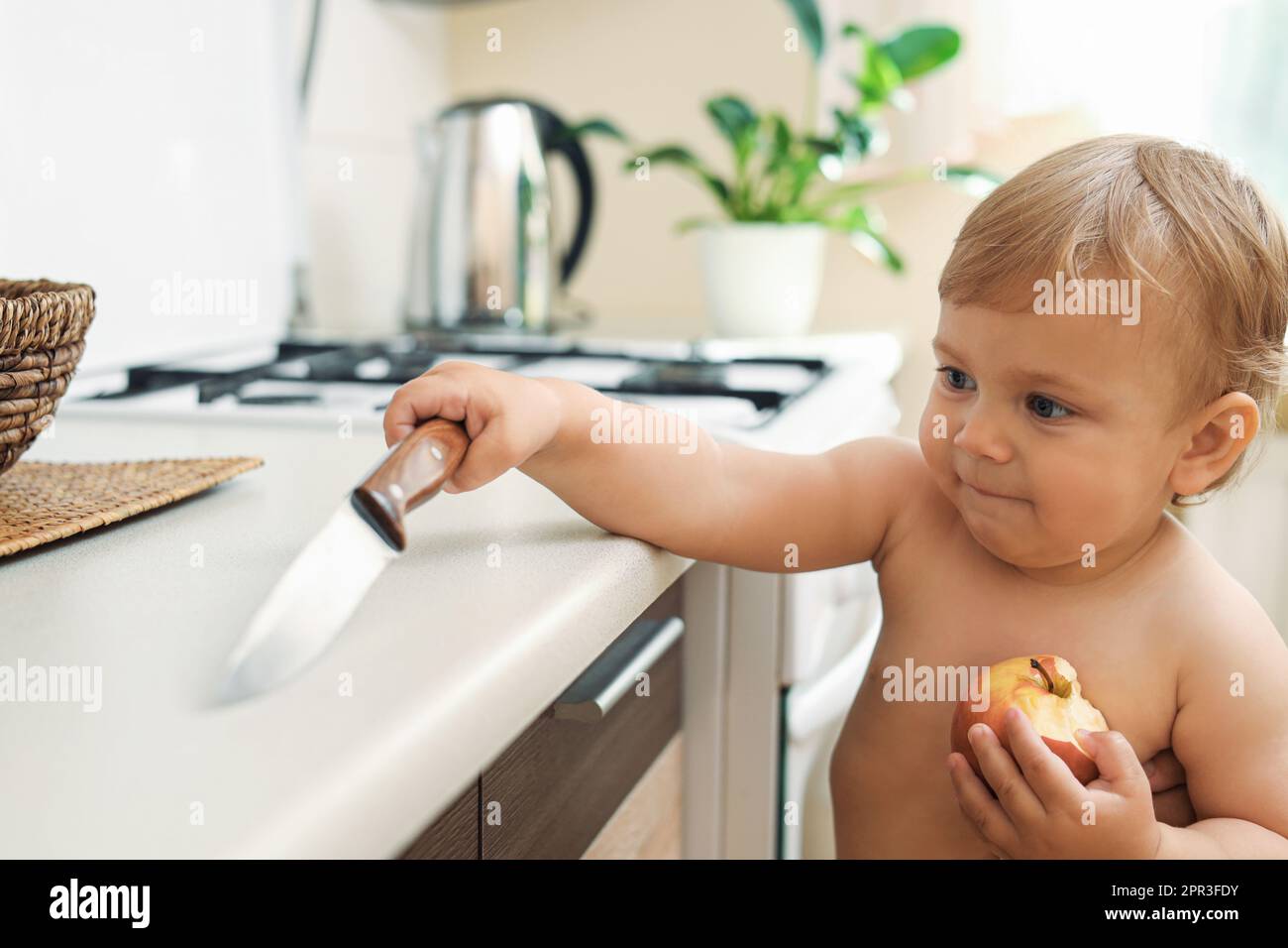 Child touches hot stove in the home. Dangerous situation in the kitchen.  Red-hot surface of hob Stock Photo by ©rbkomar 416451342