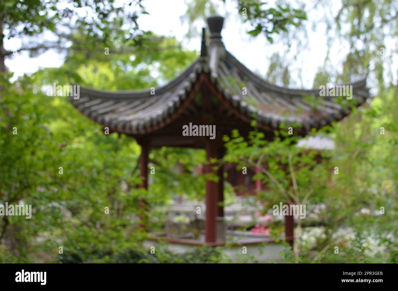 Blurred view of beautiful oriental pergola in park Stock Photo - Alamy