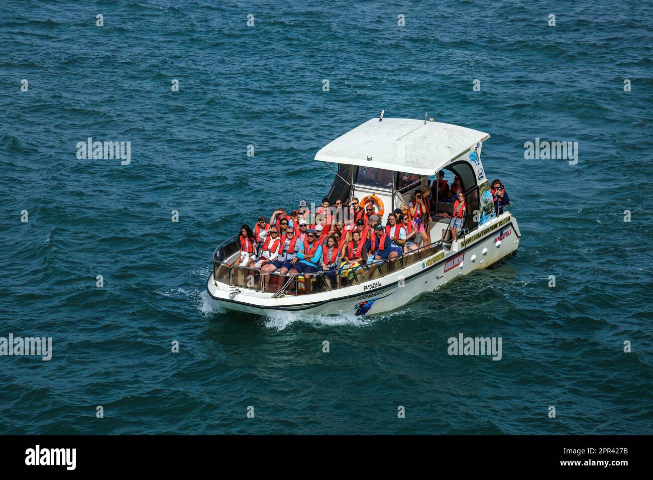 Tourists in a motorboat on the coast near Algar Seco, Portugal, Algarve Stock Photo