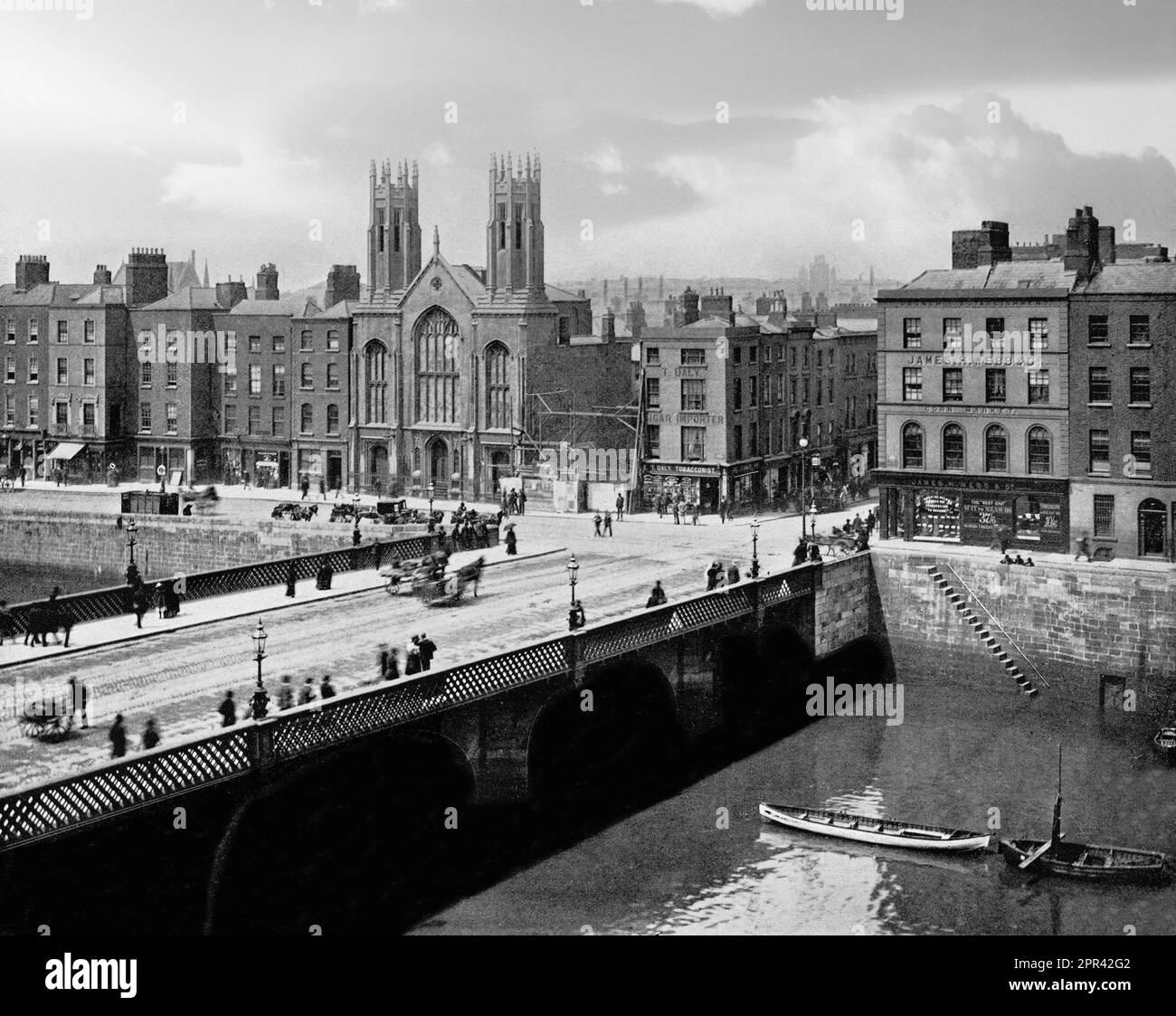 A late 19th century photograph of the Grattan Bridge, a road bridge spanning the River Liffey in Dublin, Ireland, and joining Capel Street to Parliament Street and the south quays. The first bridge, built in 1676 was named as Essex Bridge, until 1872, when the bridge was widened and flattened with cast iron supports extended out and reopened as Grattan Bridge in 1874, being named after Henry Grattan MP (1746-1820). Stock Photo