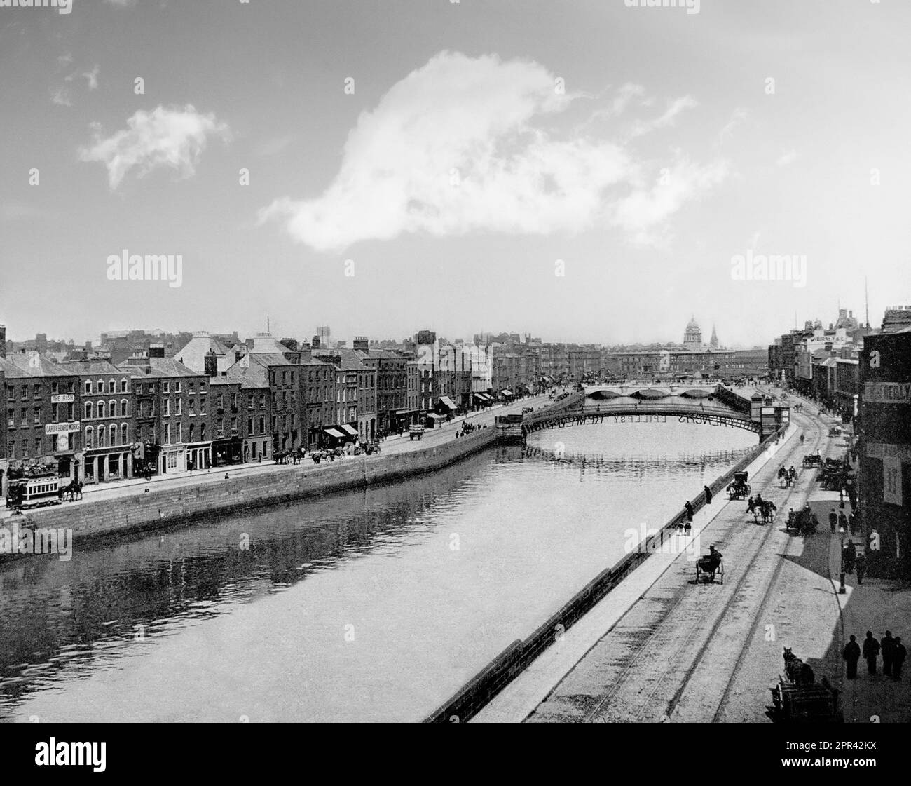 A late 19th century photograph of the quays along the River Liffey in Dunlin City, Ireland. The distant Custom House, O'Connell Bridge can be seen along with the Ha'Penny foot bridge sporting advertising 'French's Epilepsy Remedy'. Stock Photo