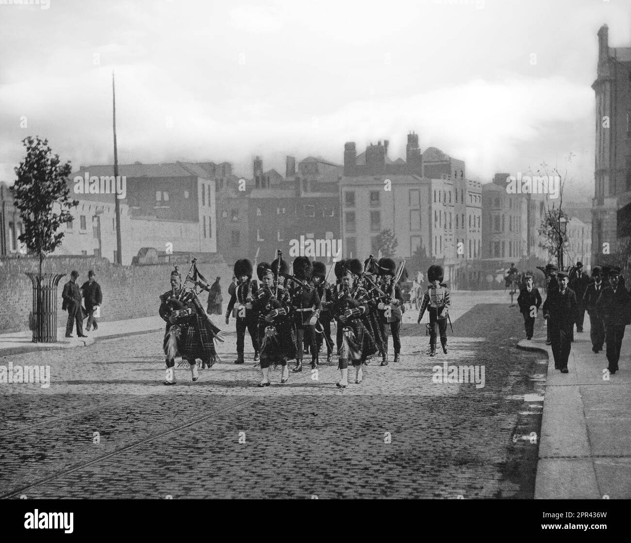 A late 19th century photograph of the Scots Guards of the British Army marching through Dublin City, Ireland. Being fellow Celts, they were more popular with locals than other army regiments. Stock Photo