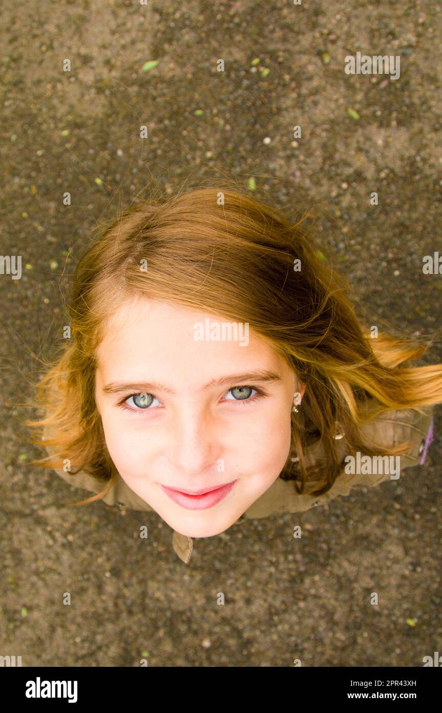 young girl looking up and smiling, top down optimistic portrait Stock Photo