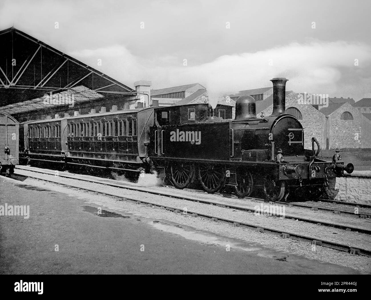 A late 19th century photograph of  steam locomotive pulling passenger coached out of Heuston Station. Stock Photo