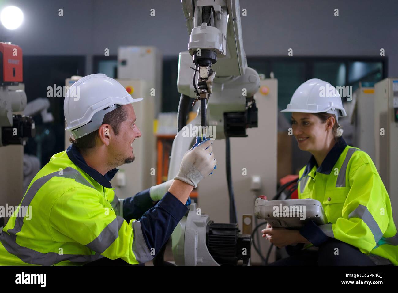 Engineer work at robotic arm factory. Technology and engineering concept. Stock Photo