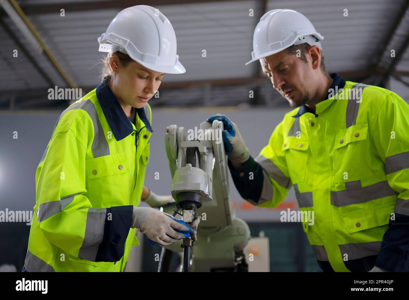 Engineer work at robotic arm factory. Technology and engineering concept. Stock Photo