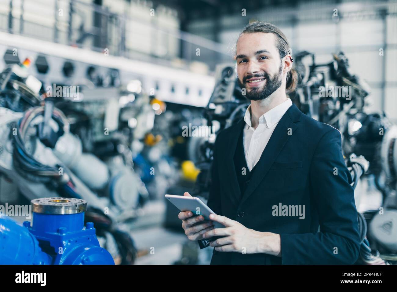 Portrait jewish businessman standing happy in machine factory warehouse for success CEO business industry owner Stock Photo