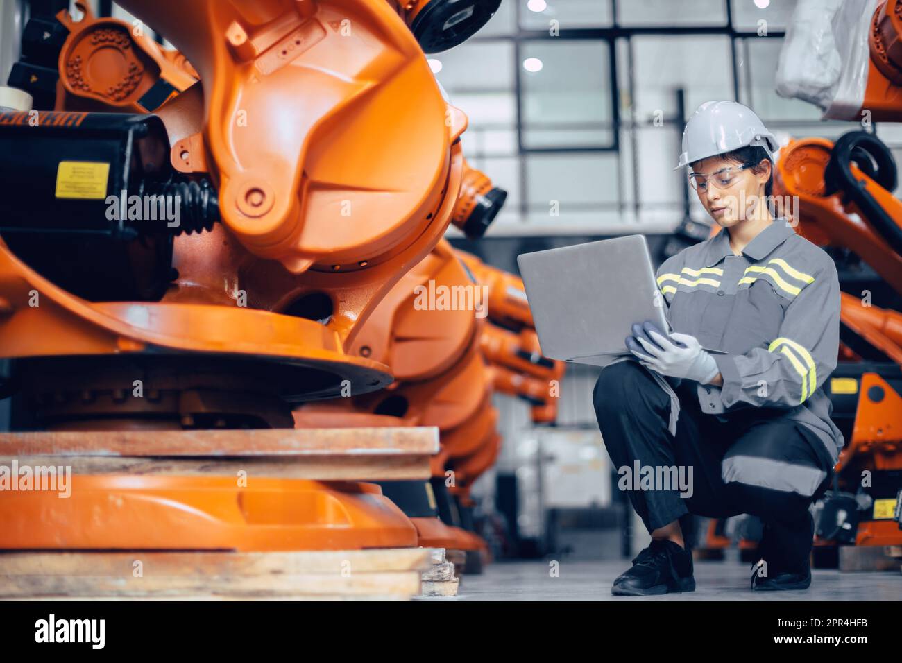 Smart engineer working woman working machine inspector with laptop computer in assembly plant Stock Photo