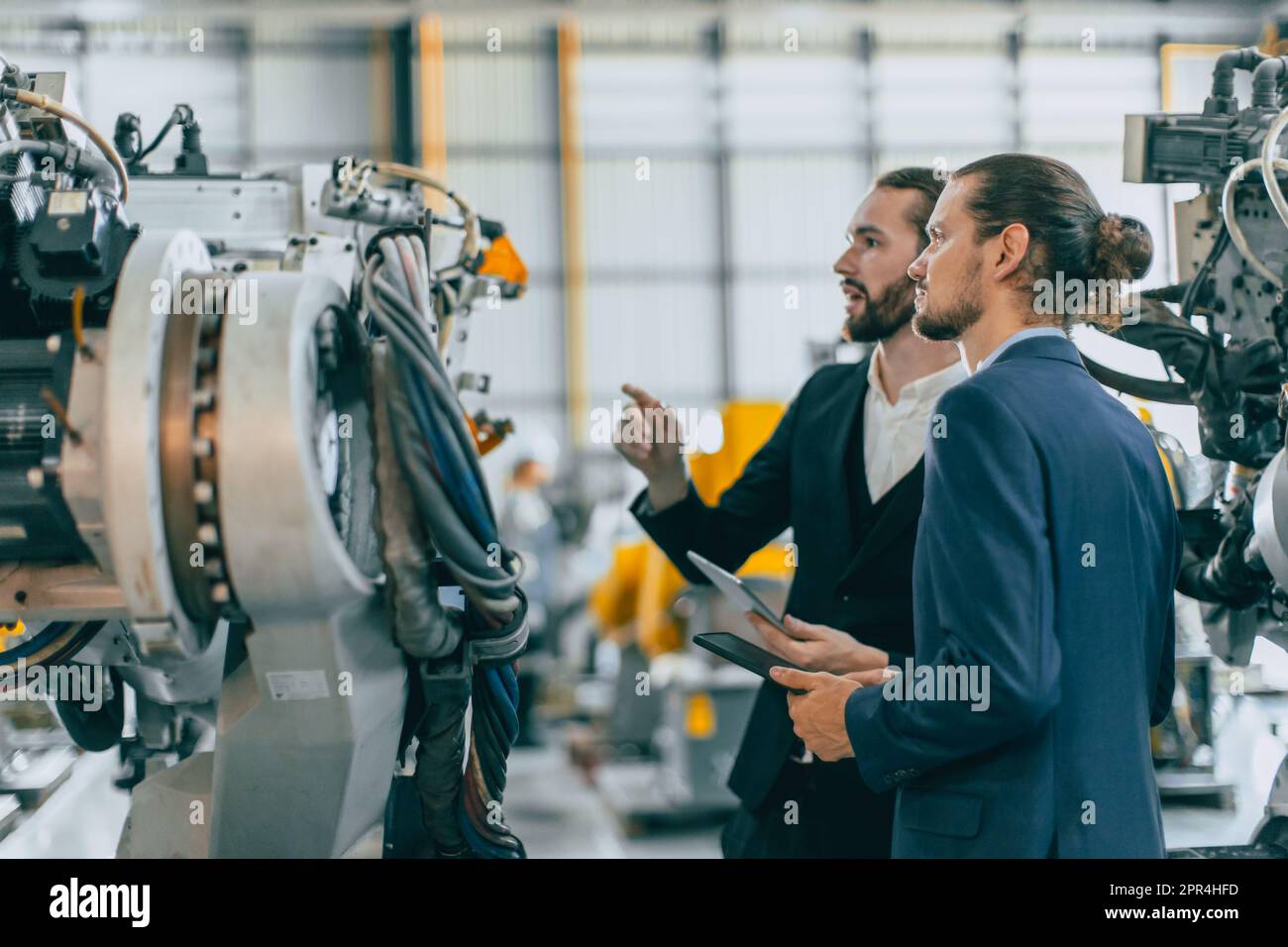 Businessman working in machinery factory robot assembly plant team working together Stock Photo