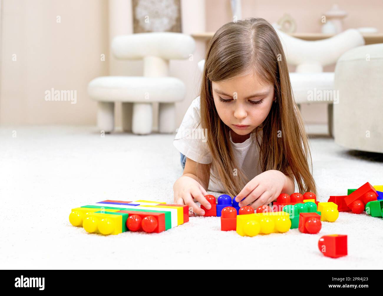 Little girl playing with toys in the children's room Stock Photo - Alamy