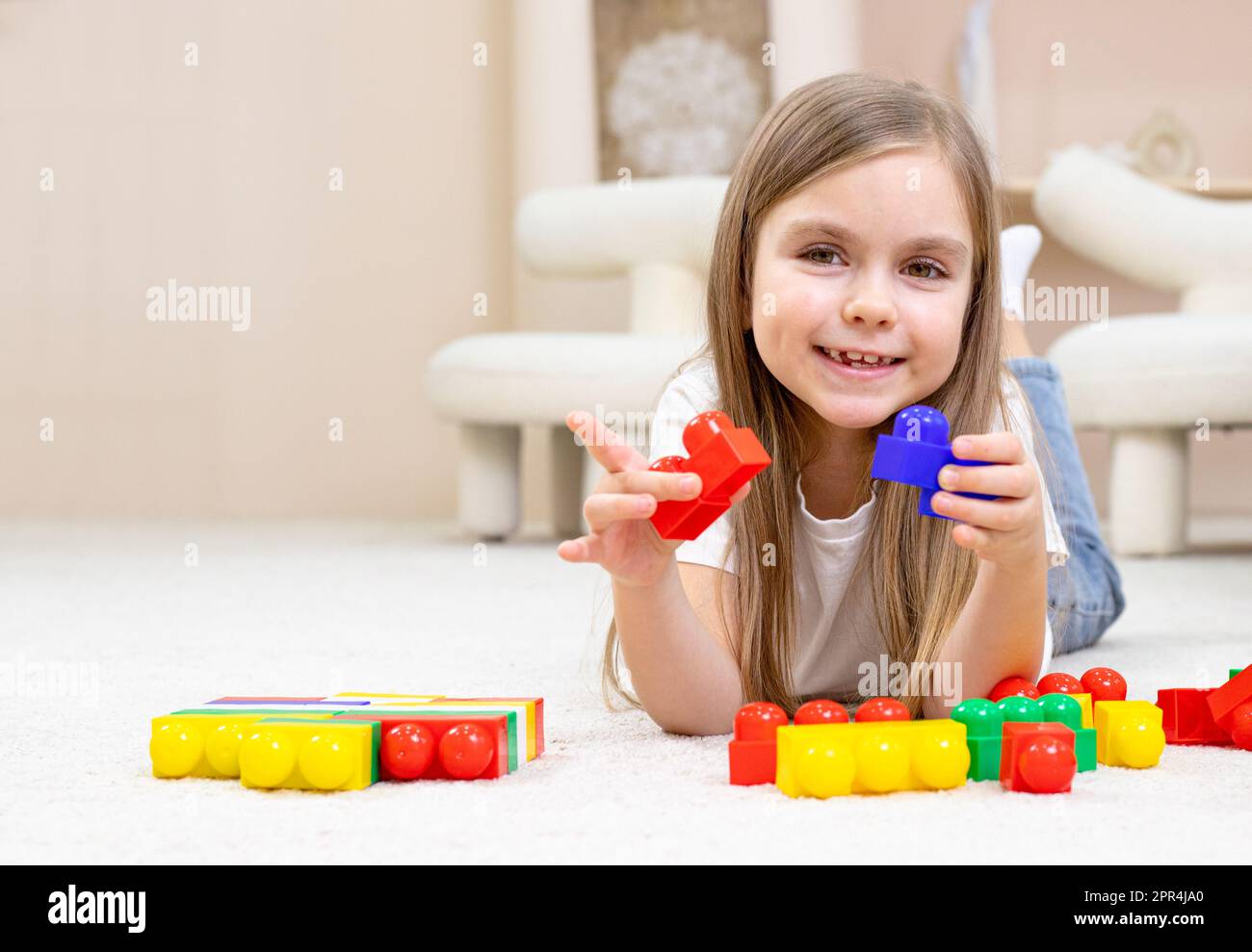 Little girl playing with toys in the children's room Stock Photo - Alamy