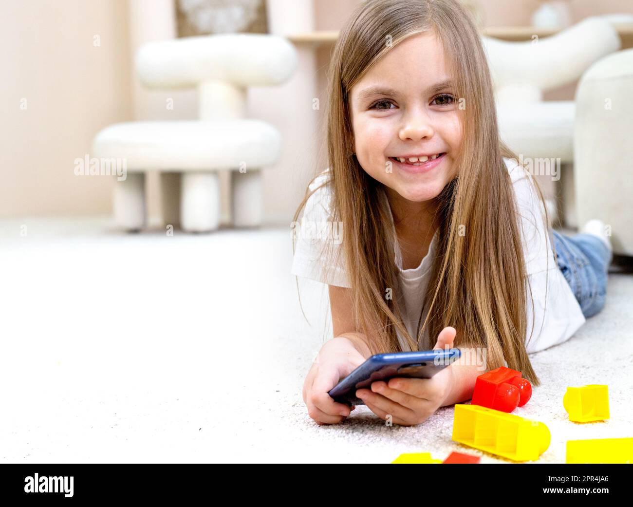 Little girl playing with toys in the children's room Stock Photo - Alamy