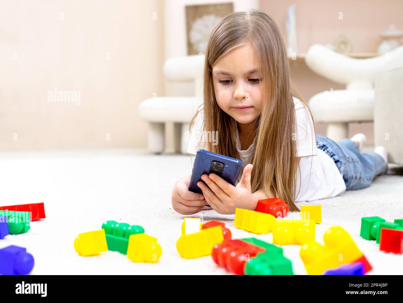 Little girl playing with toys in the children's room Stock Photo - Alamy